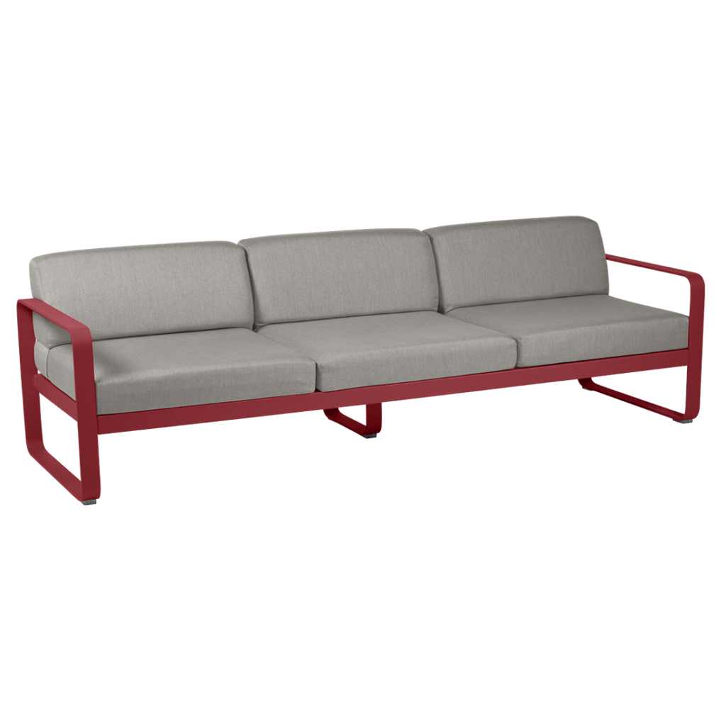 Un canapé rouge avec des coussins gris sur fond blanc.