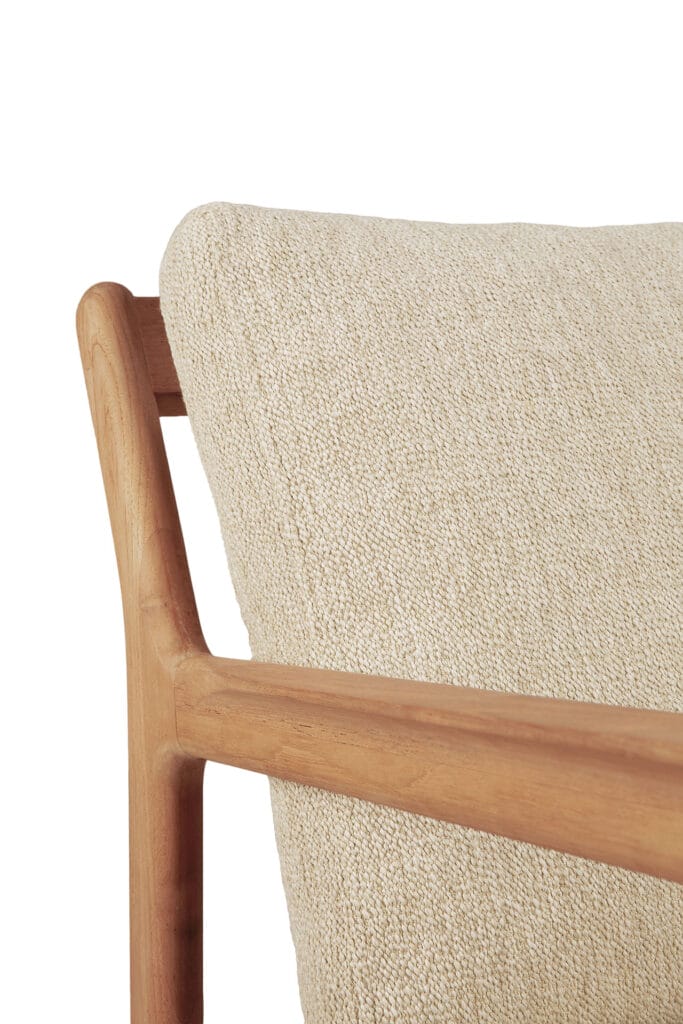 Un gros plan d'une chaise en teck avec un coussin beige.