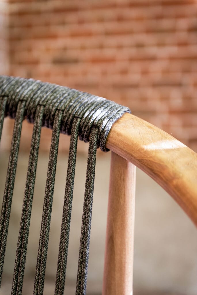 Un gros plan d'une chaise en bois avec une corde dessus.
