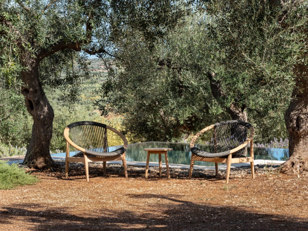 Deux chaises au milieu d’une pelouse au bord d’une piscine.
