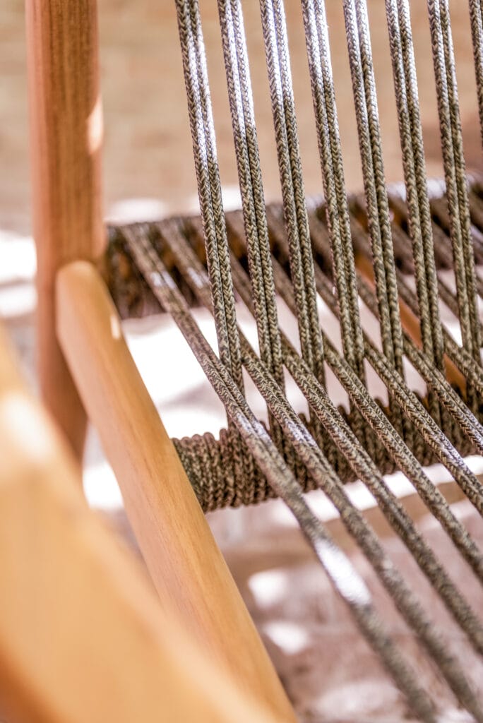 Un gros plan d'une chaise en bois avec des cordes dessus.