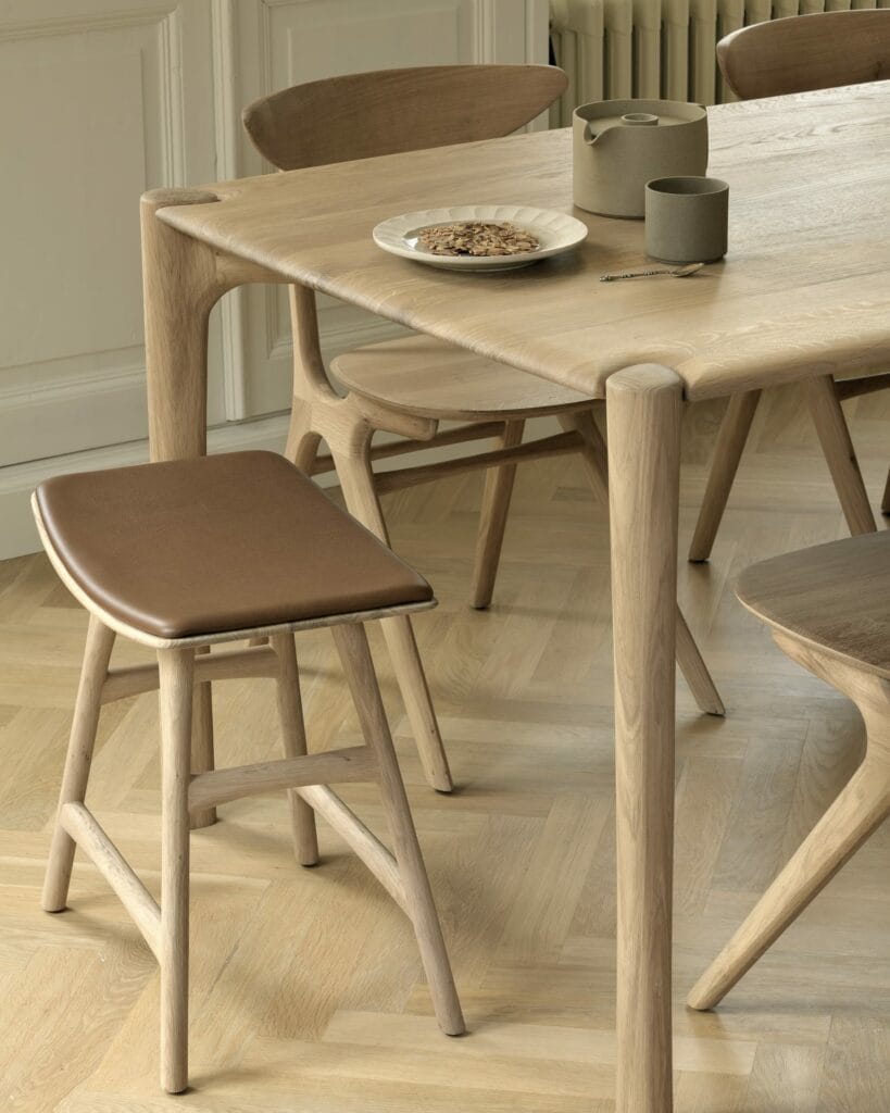 Une table à manger en bois avec chaises et tabourets Osso.