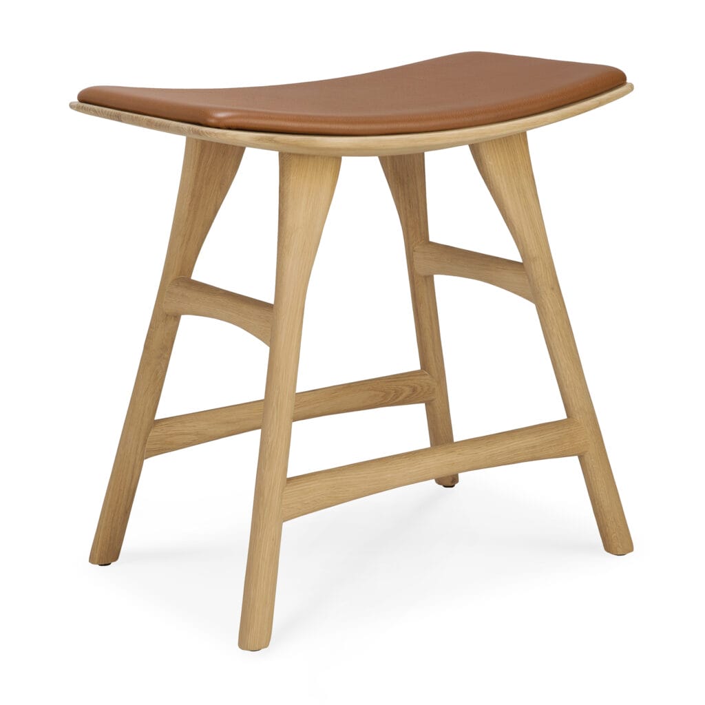 Un tabouret en bois avec un siège en cuir brun.