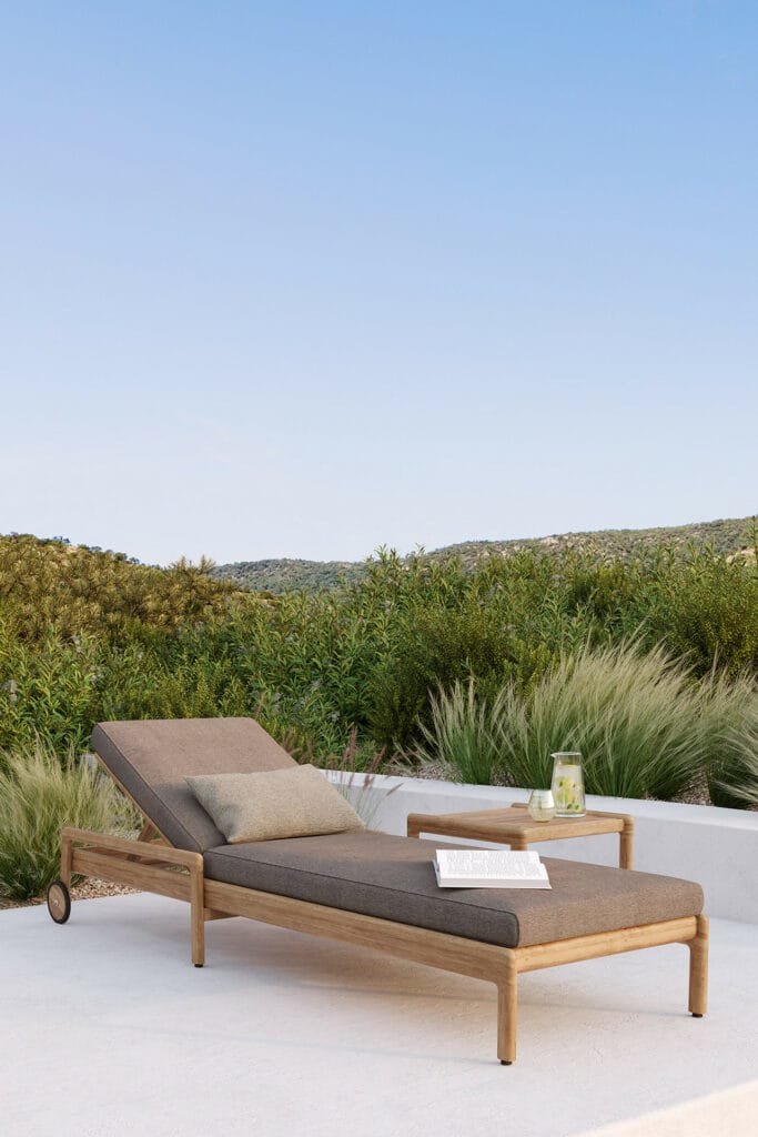 Une chaise longue en bois sur une terrasse avec vue sur les montagnes, conçue par quatuor design.