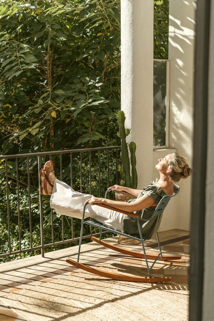 Rocking Chair Étonnamment, une femme est assise sur un balcon.