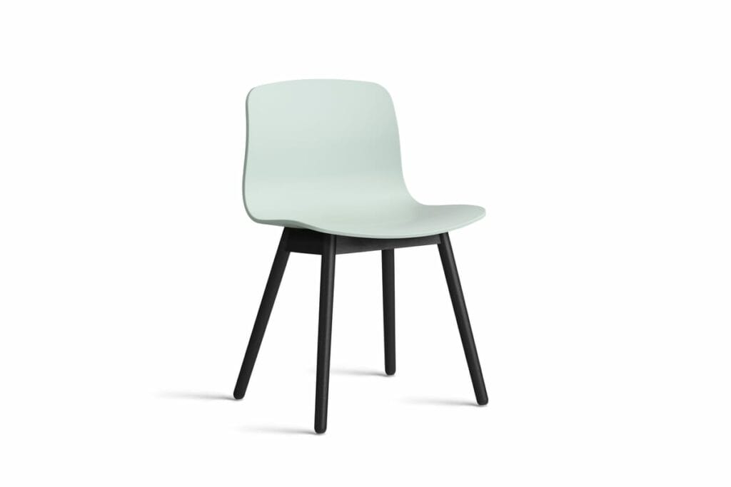 Une chaise verte avec des pieds noirs sur fond blanc.