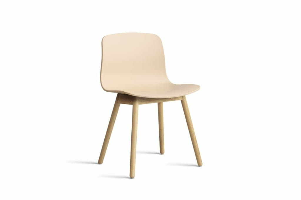 Une chaise beige avec des pieds en bois sur fond blanc.