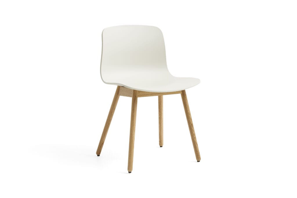 Une chaise blanche AAC12 avec des pieds en bois sur fond blanc.