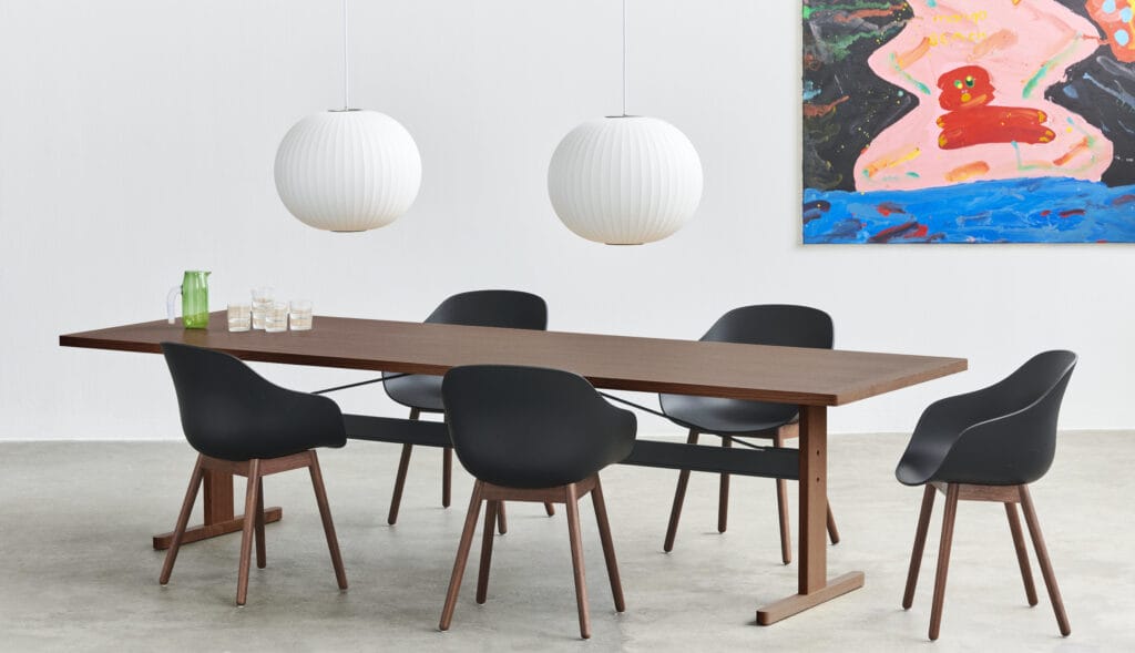 Une table à manger avec des chaises Chaise AAC212 et un tableau au mur.