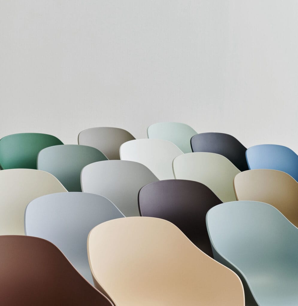 Une rangée de chaises colorées Chaise AAC212 dans une pièce blanche.