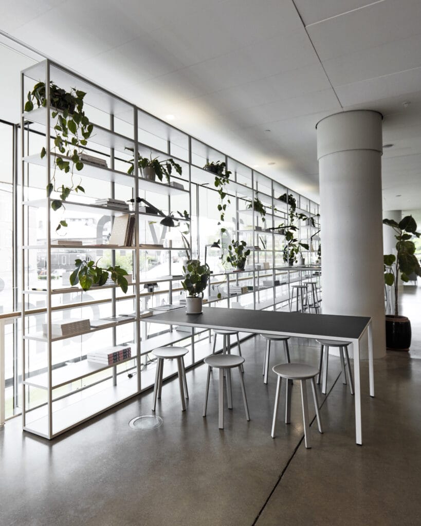 Une pièce avec des chaises et des plantes, mais aussi un Tabouret Revolver posé sur une table.