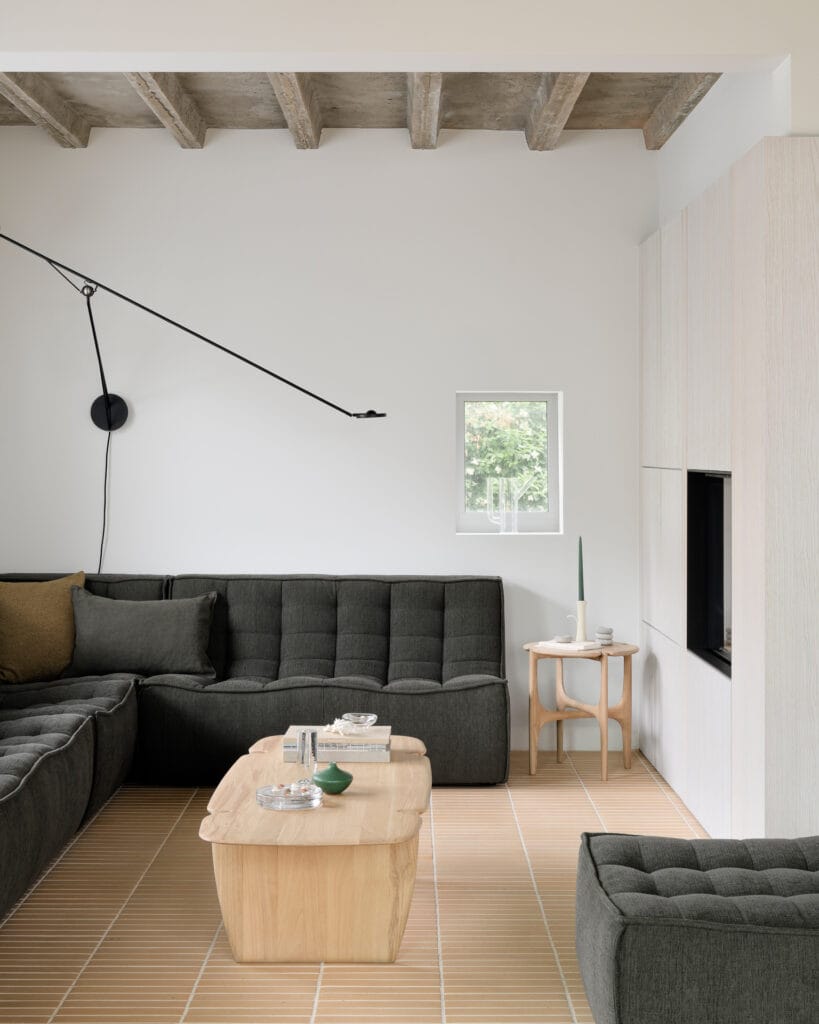 Un salon avec un canapé noir et une table d'appoint PI.