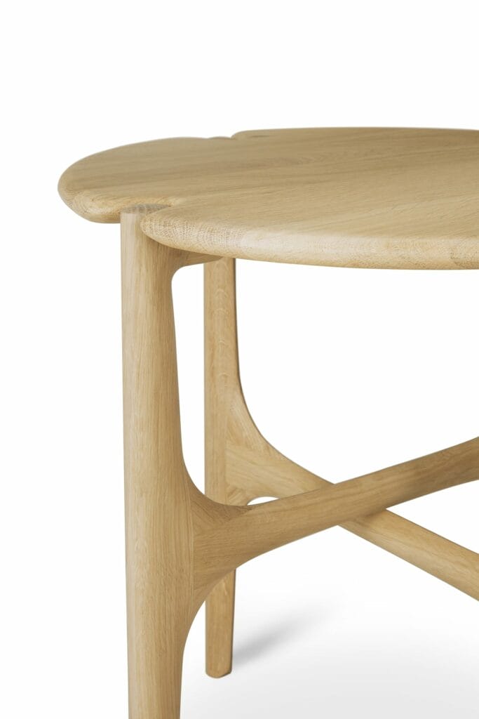 Une table d'appoint ronde PI en bois avec pieds croisés.
