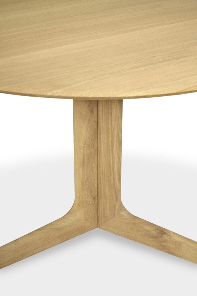 La Table Corto ronde, une table ronde en bois avec un piètement en bois, apporte à la fois élégance et fonctionnalité à n'importe quel espace.