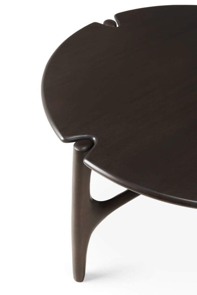 Une table basse ronde PI avec un piètement en bois.