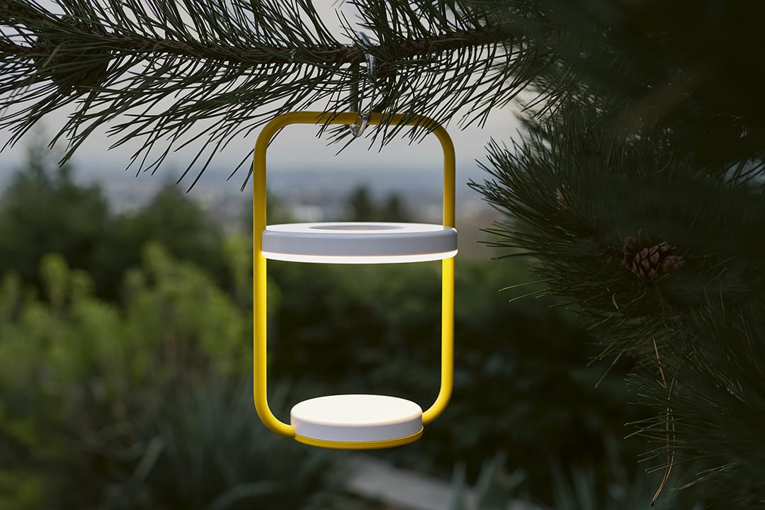 Vivo 53 jaune moderne suspendu à une branche de pin avec un arrière-plan flou représentant un paysage urbain.