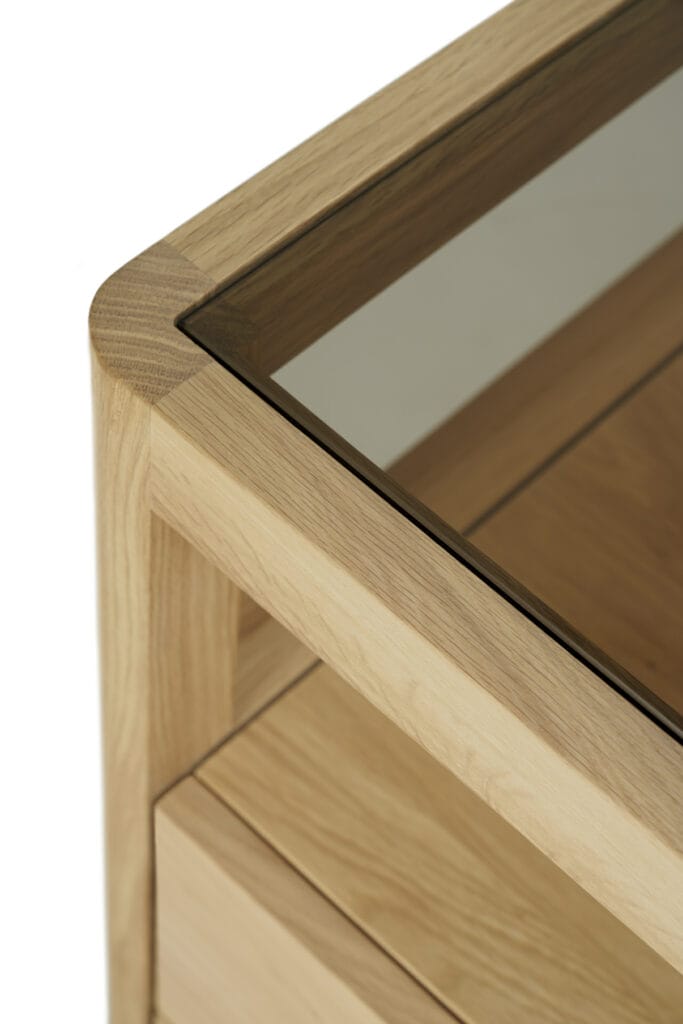 Une vue rapprochée d'une Commode Spindle en chêne avec un plateau en verre en chêne.