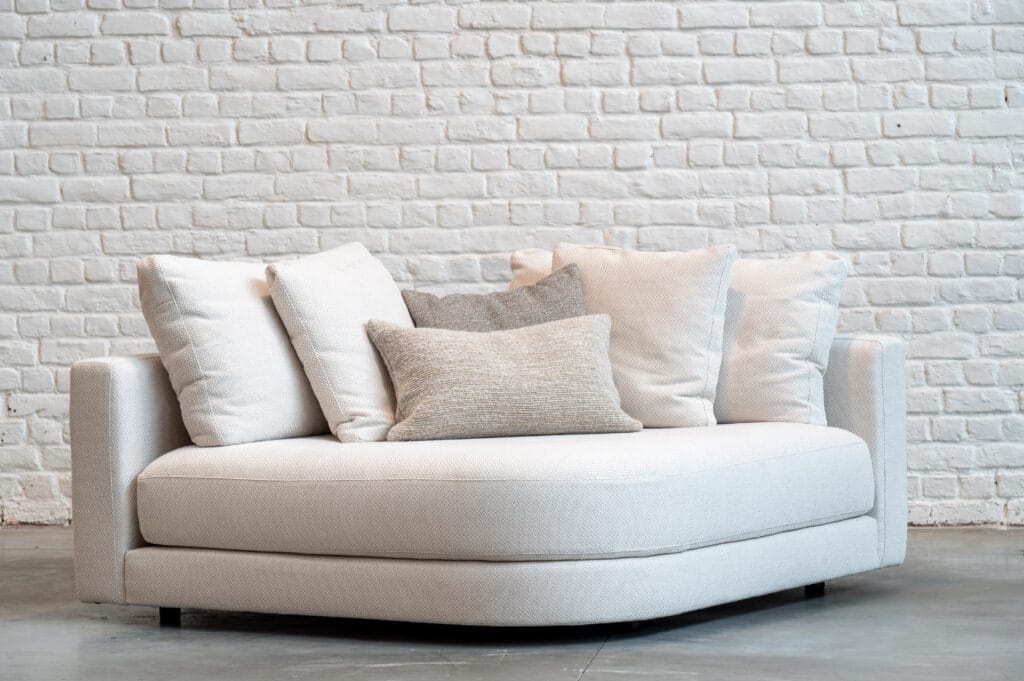 Un Canapé Stone devant un mur en tissu Osier.