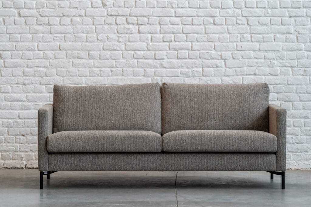 Un Canapé Impulse, tissu Se faufiler devant un mur de briques.