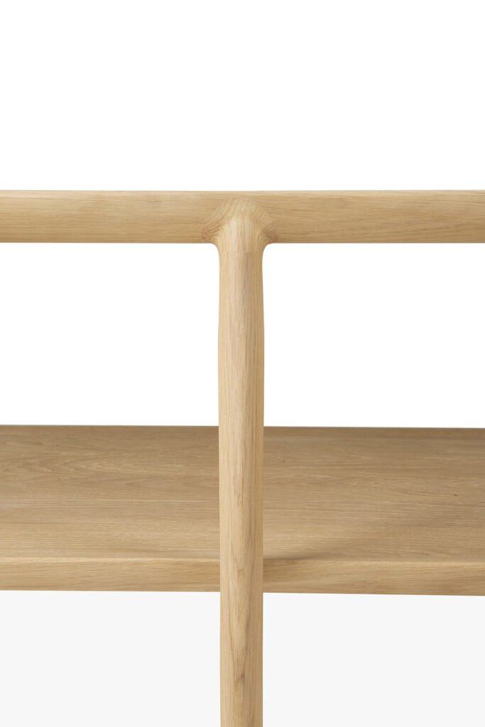 Gros plan d’une étagère en bois avec une intersection en forme de T, mettant en valeur la finition lisse et naturelle du bois. Parfait pour exposer les accessoires carrés de la table à manger Bok ou pour ajouter une touche d'élégance à la décoration de votre pièce carrée.