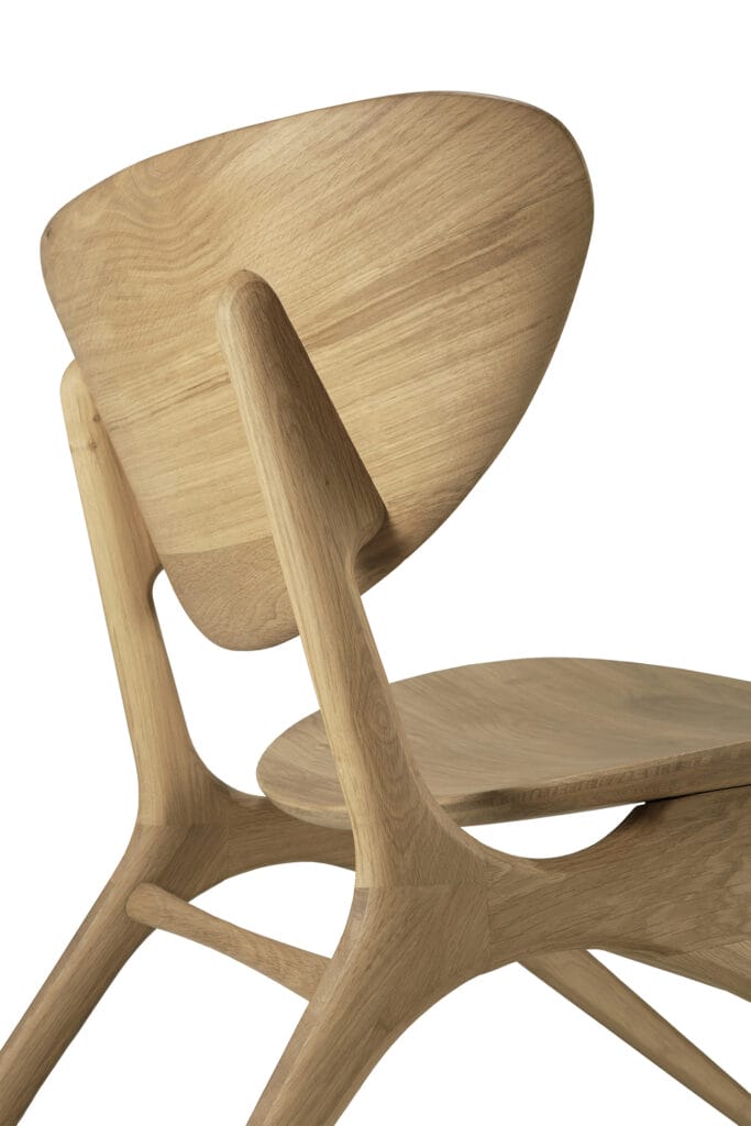Un Fauteuil Eye, fabriqué en bois de chêne huilé naturel, doté d'un dossier incurvé.