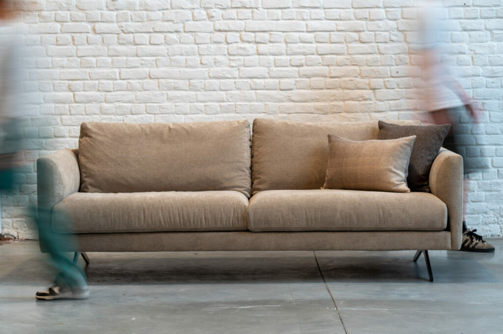 Deux personnes marchant devant une Expo - Canapé Diva.