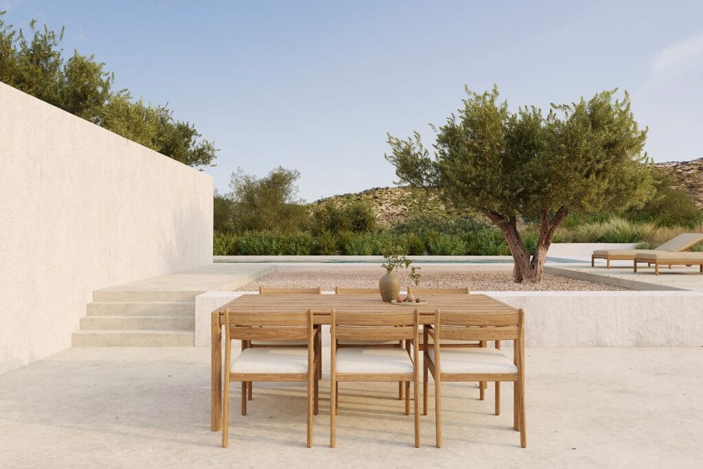 Un coin repas extérieur avec une table en bois et des chaises de salle à manger d'extérieur Jack avec accoudoirs.