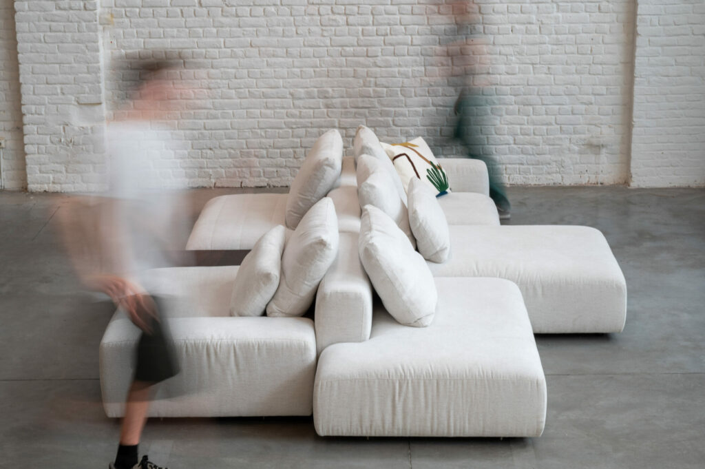 Un groupe de personnes passant devant un canapé blanc en Expo - Canapé Reverso, tissu Cottage 3715.