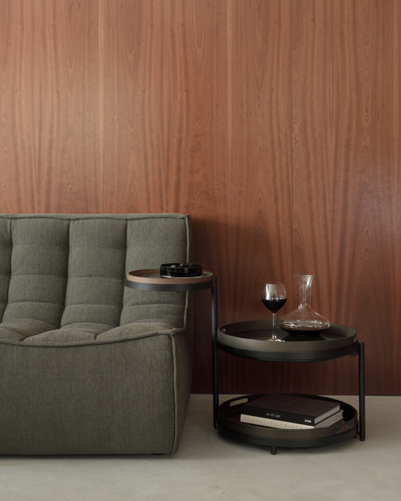 Un canapé gris devant une Table d'appoint à plateau pivotant en bois.