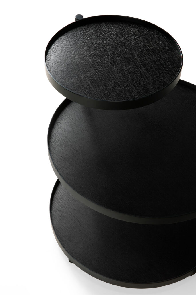 Une Table d'appoint à plateau Pivotant à trois plateaux sur le dessus.