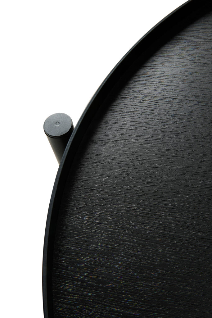 Un gros plan d'une table d'appoint à plateau noire pivotante avec une poignée.