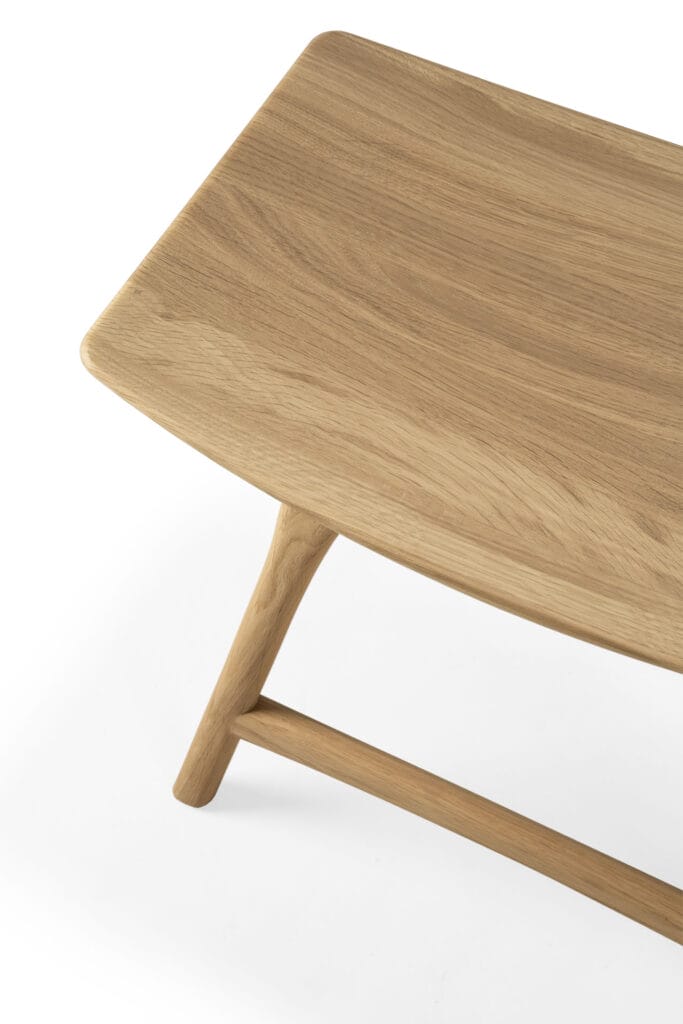 Une table basse en bois avec une base Tabouret Osso.
