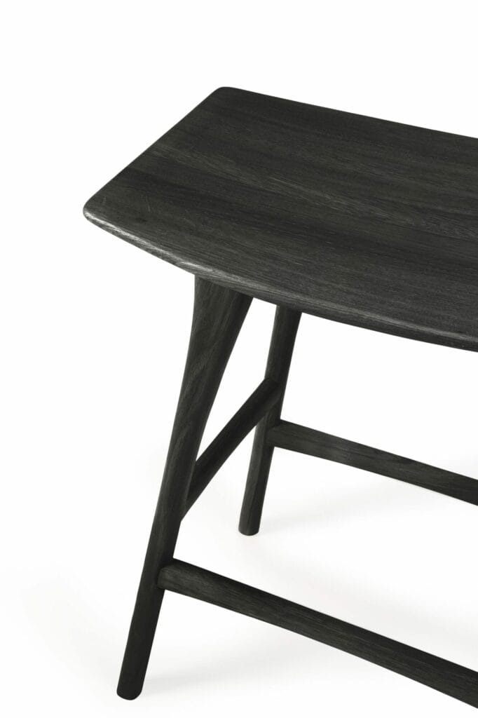 Un tabouret de bar en chêne teinté noir avec un dessus en bois verni.