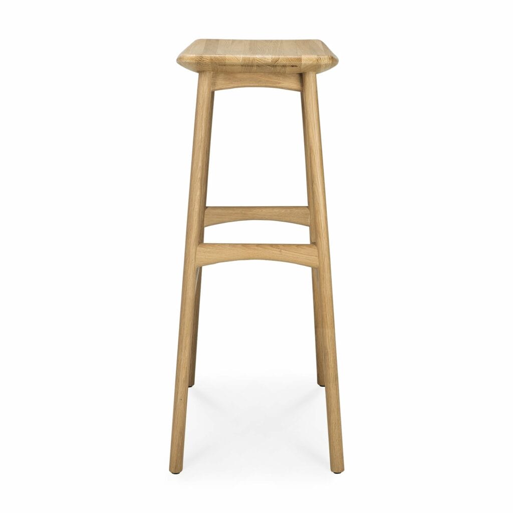 Un tabouret de bar en bois sur fond blanc en chêne huilé naturel.