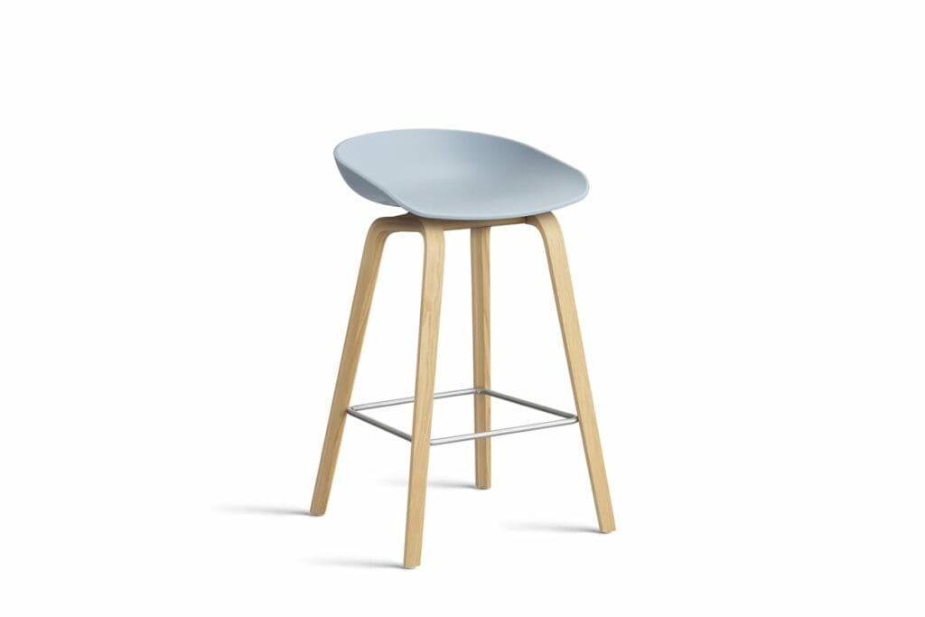 Un tabouret bleu clair avec des pieds en bois.
