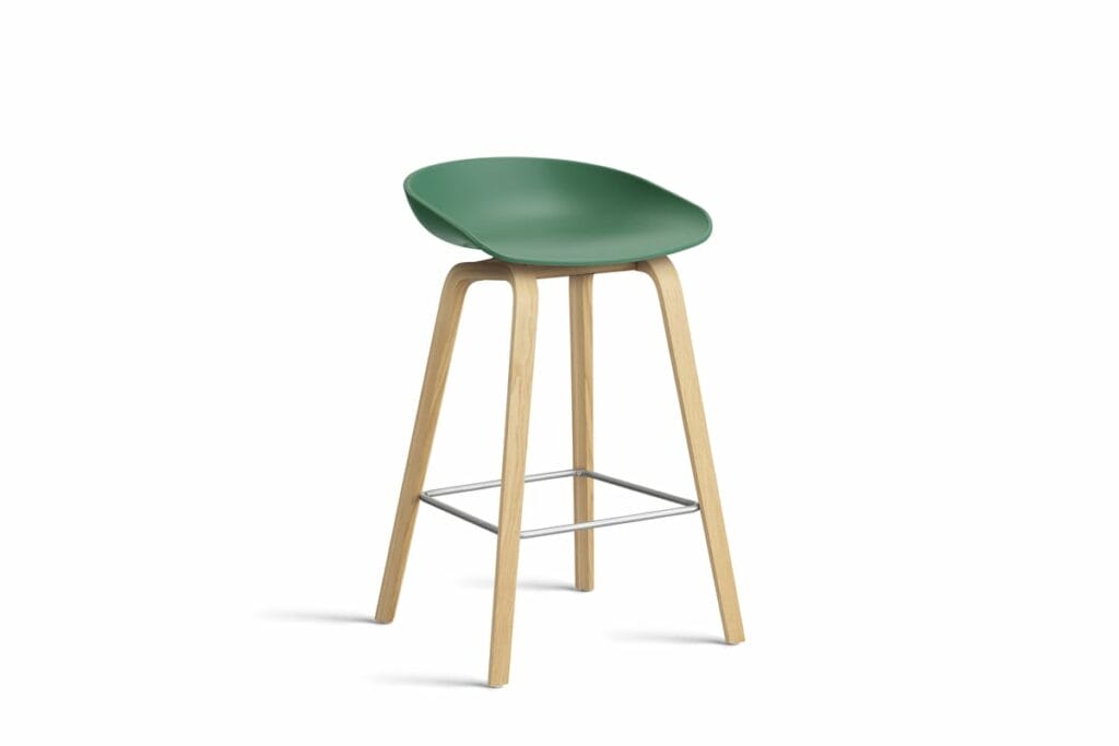 Un tabouret vert avec des pieds en bois.
