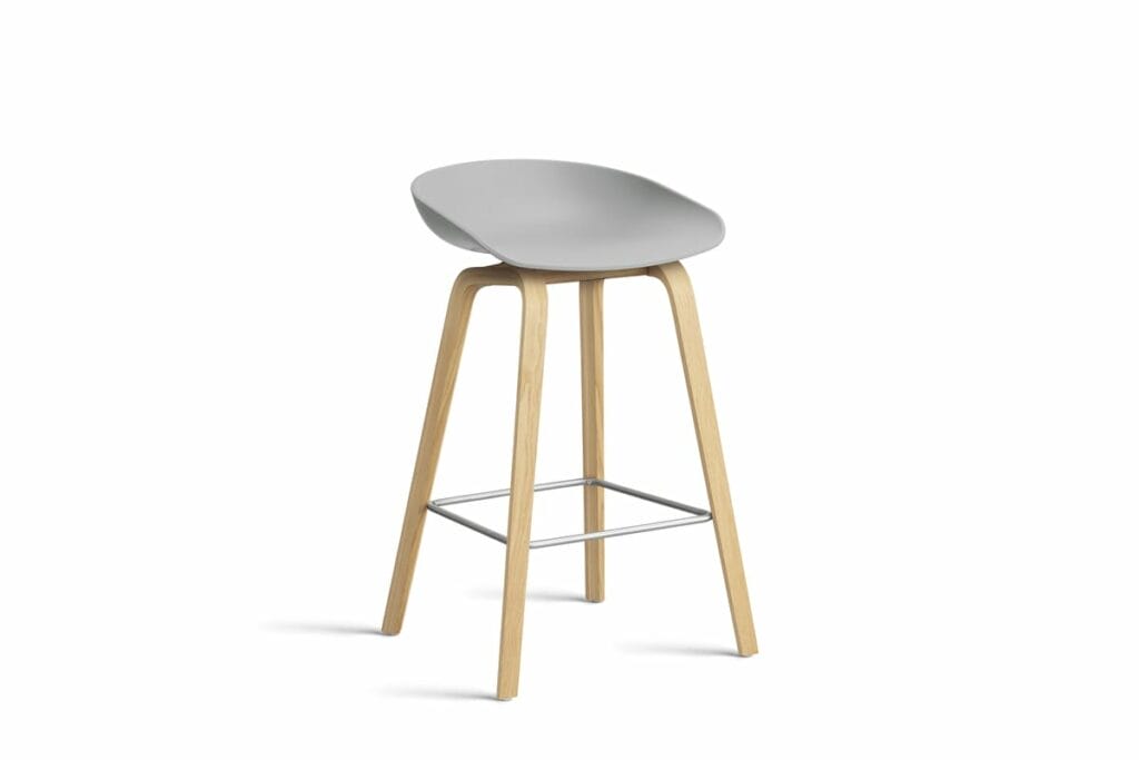 Un tabouret gris avec des pieds en bois sur fond blanc.