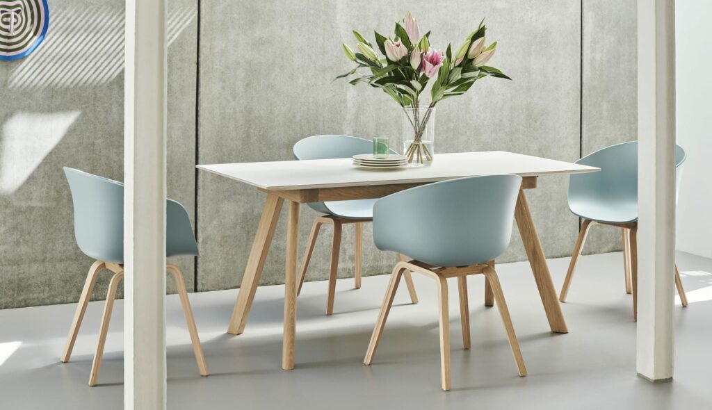 Une table à manger avec quatre chaises et un vase, avec des chaises Chaise AAC22.