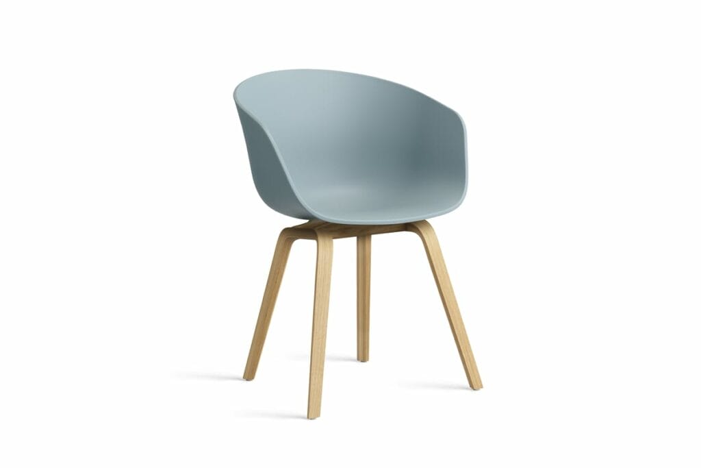 Une chaise AAC22 bleue avec des pieds en bois sur fond blanc.