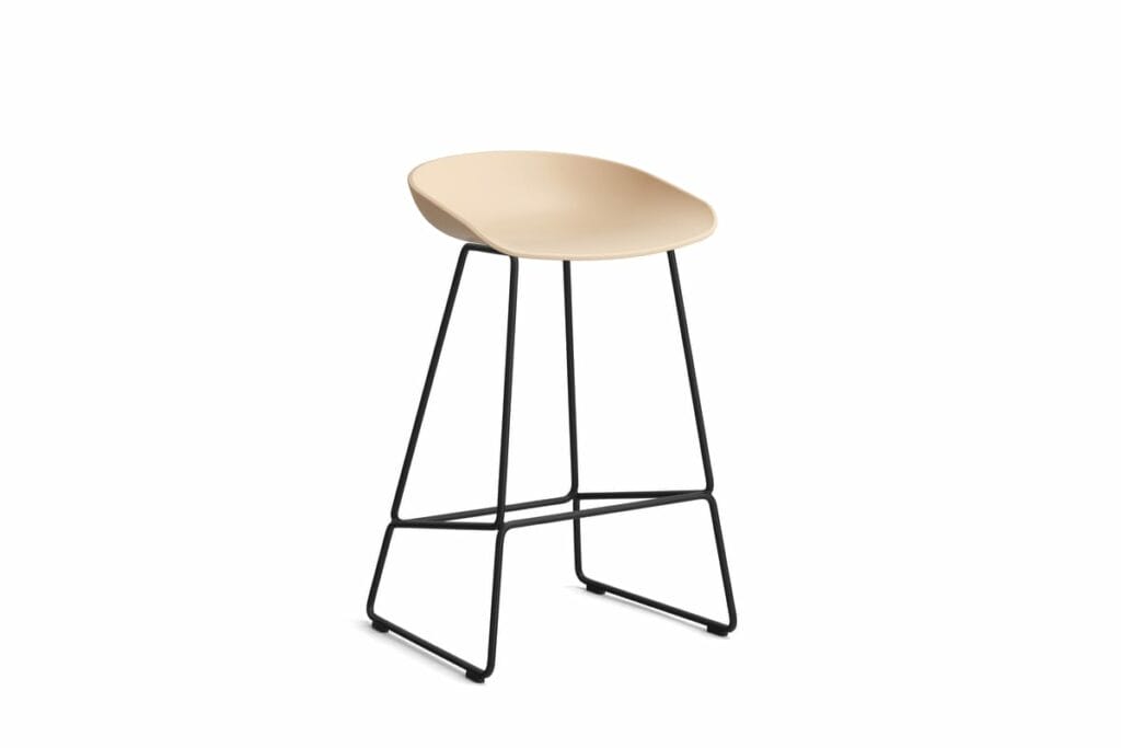 AAS38, Tabouret - Un tabouret de bar avec une assise beige et des pieds noirs.