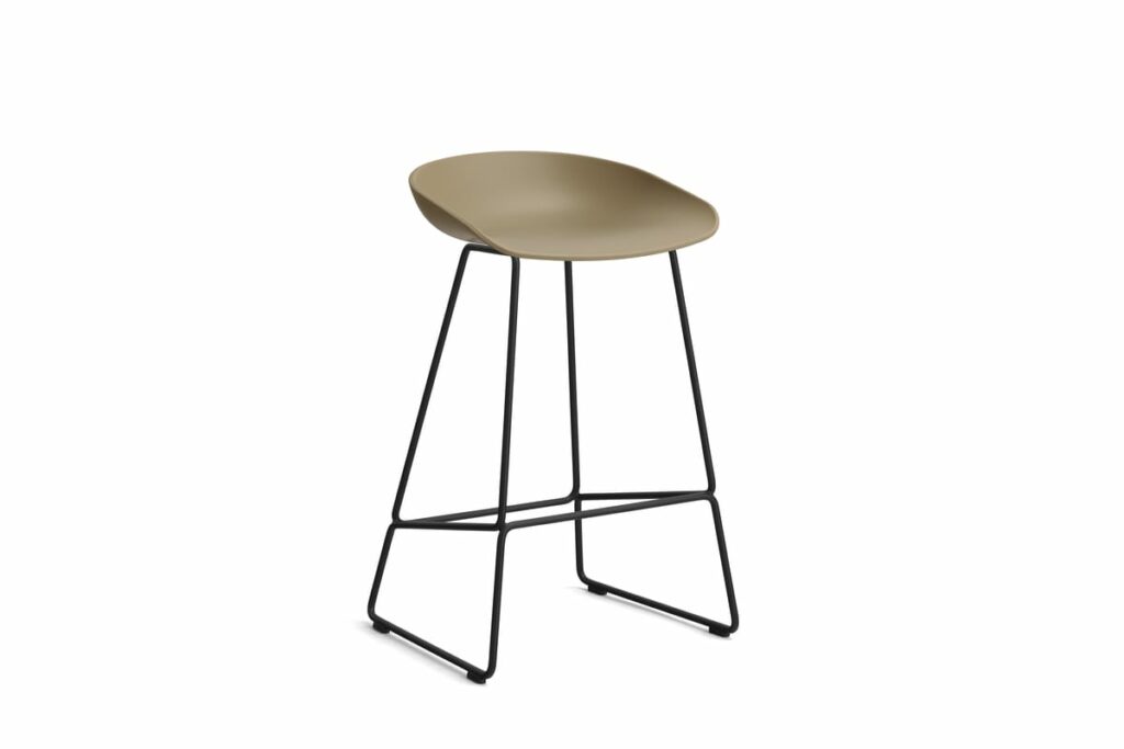 Un tabouret de bar beige avec des pieds noirs de Tabouret.