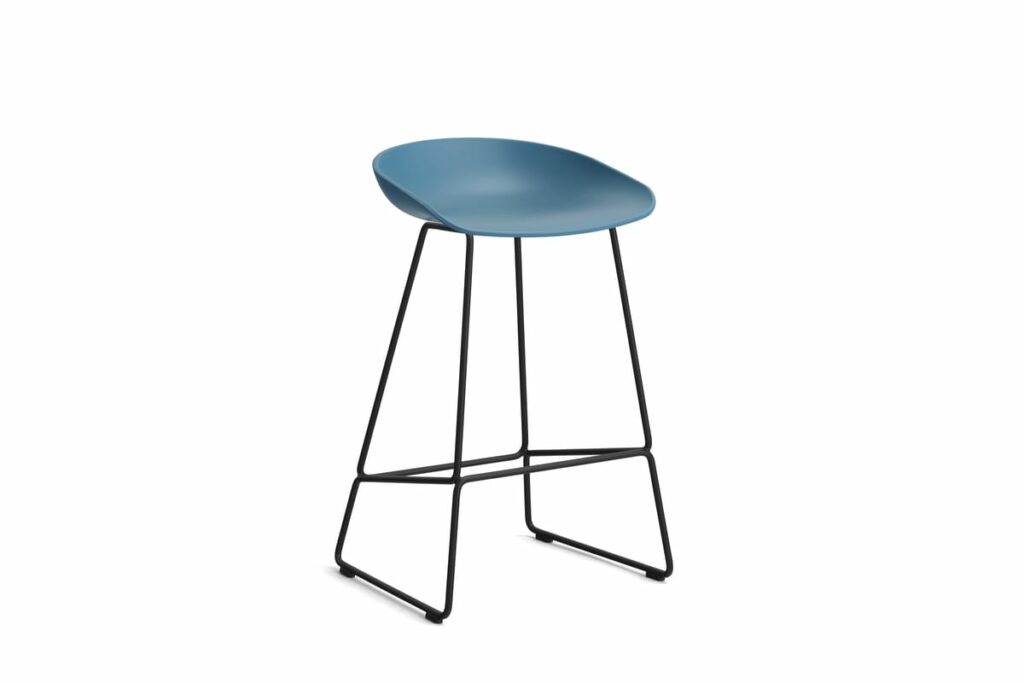 Un tabouret de bar bleu avec des pieds noirs sur fond blanc.