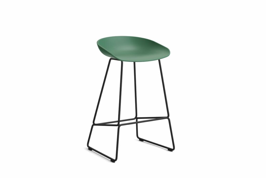 Un tabouret de bar Tabouret vert avec des pieds noirs sur fond blanc.