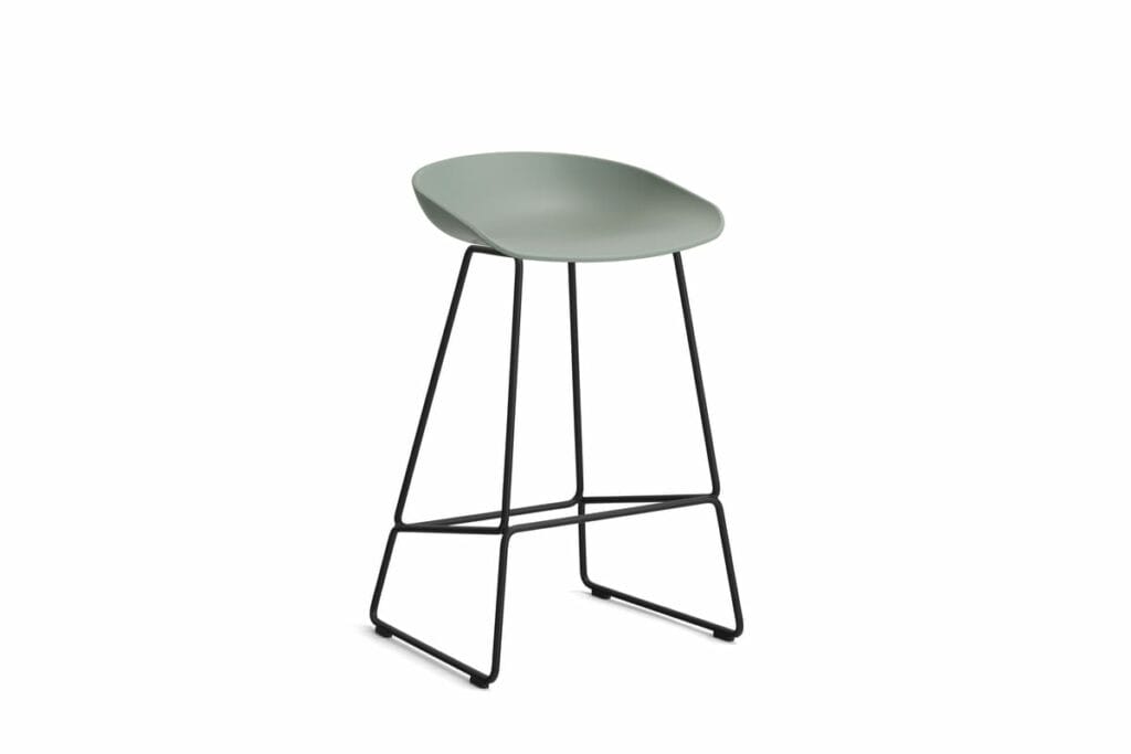 Un tabouret vert avec des pieds noirs.