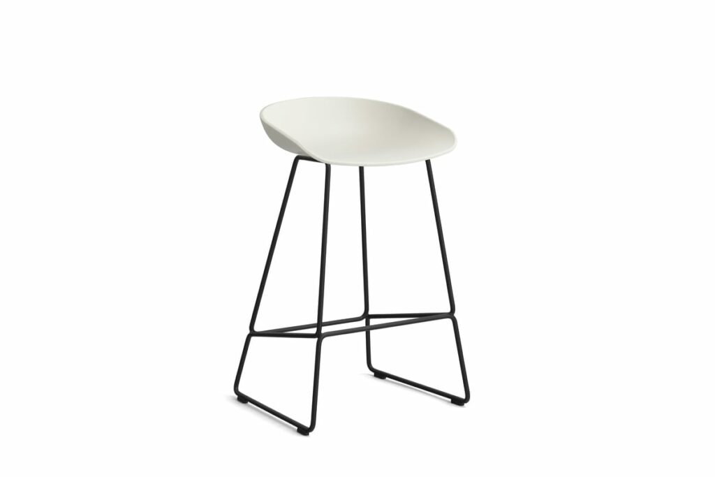 Un tabouret Tabouret blanc avec des pieds noirs sur fond blanc.