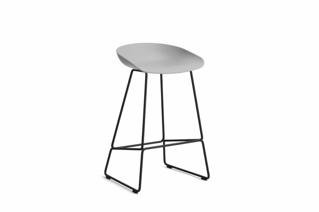 Un tabouret de bar gris avec des pieds noirs sur fond blanc.
