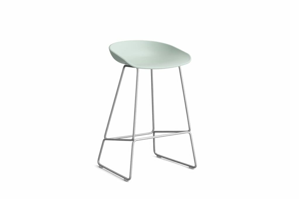 Un tabouret vert sur fond blanc.