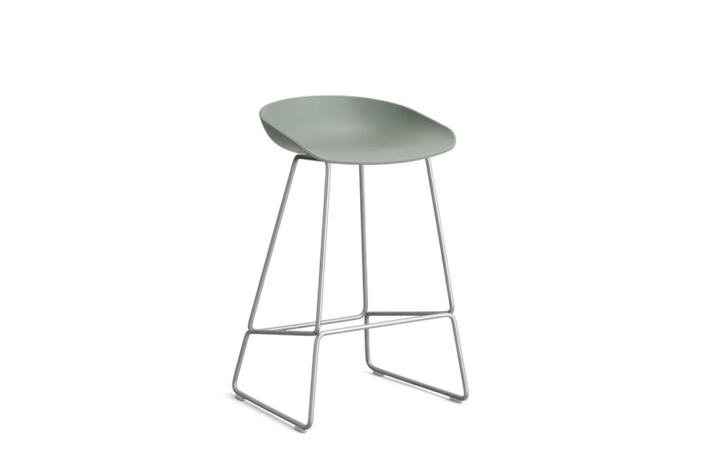 Un tabouret vert avec une structure en métal sur fond blanc.