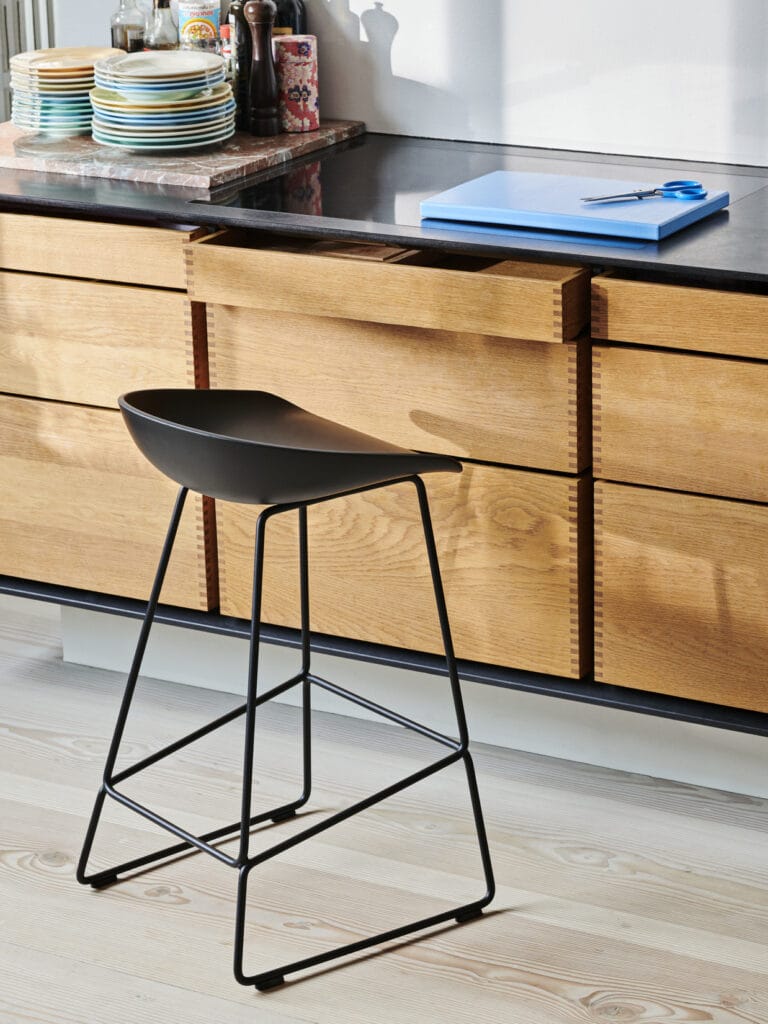 Un tabouret de comptoir AAS38 noir dans une cuisine.