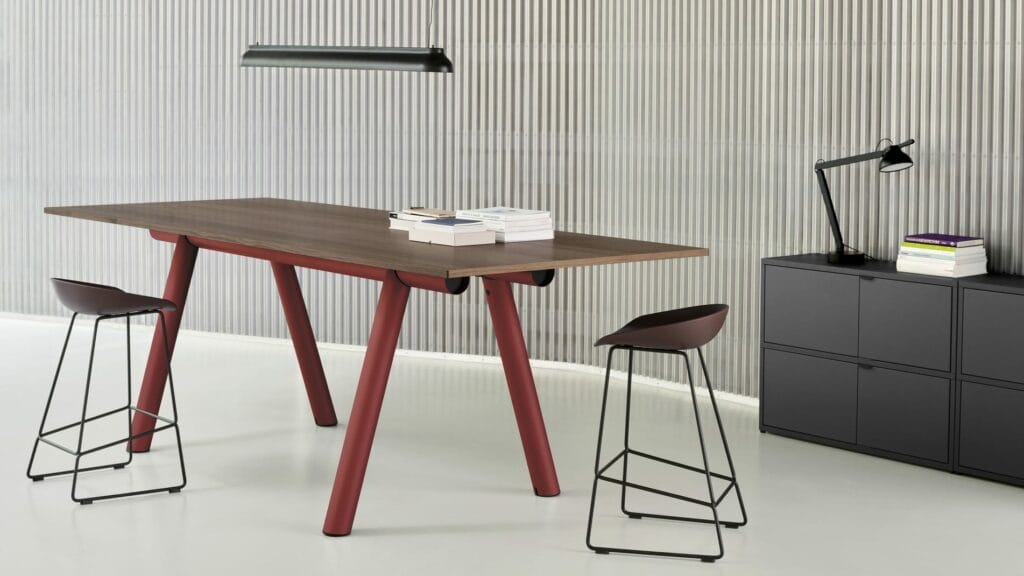 Un bureau avec deux tabourets et une bibliothèque comportant un tabouret.